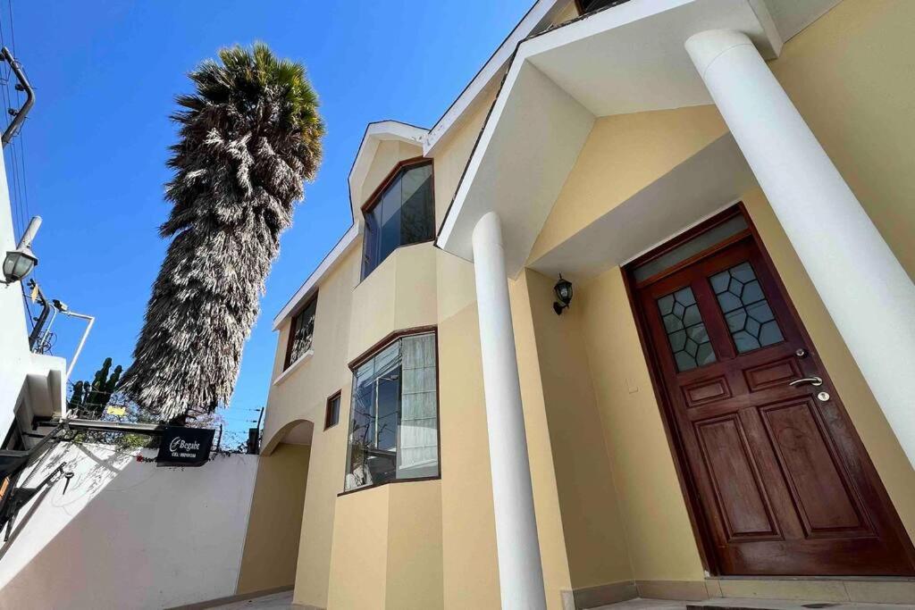 Hermosa Casa completa en Arequipa的一座有门和棕榈树的房子