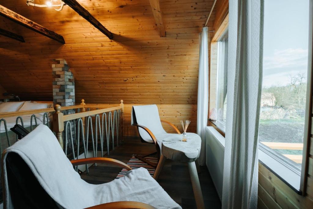 锡比乌Little Bear Lodge的门廊配有椅子和桌子,设有窗户
