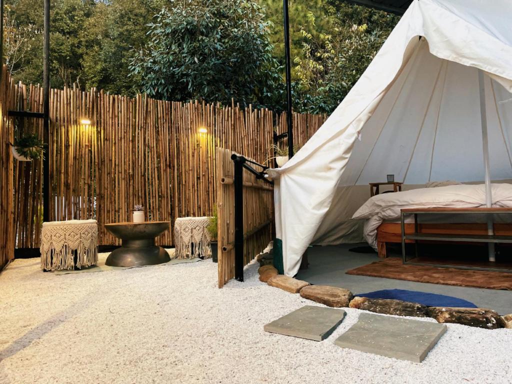 穆克缇斯瓦Bell Glamping - Luxury Bath in Mukteshwar's Nature的帐篷配有床和围栏