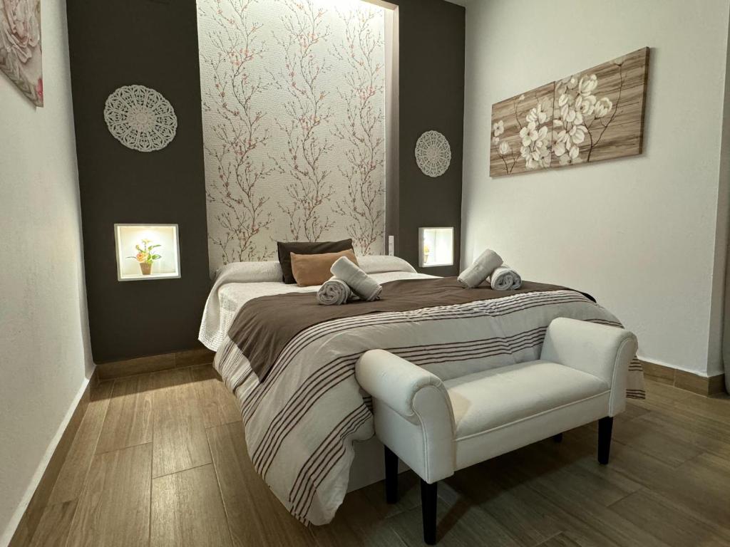科尔多瓦Noches de Córdoba的一间卧室配有一张大床和一把椅子