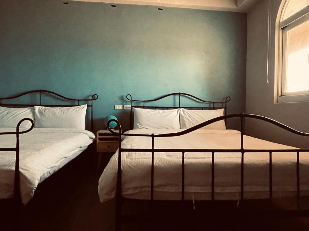 Lanyu兰屿IGANG文旅的卧室设有两张床铺,拥有蓝色的墙壁