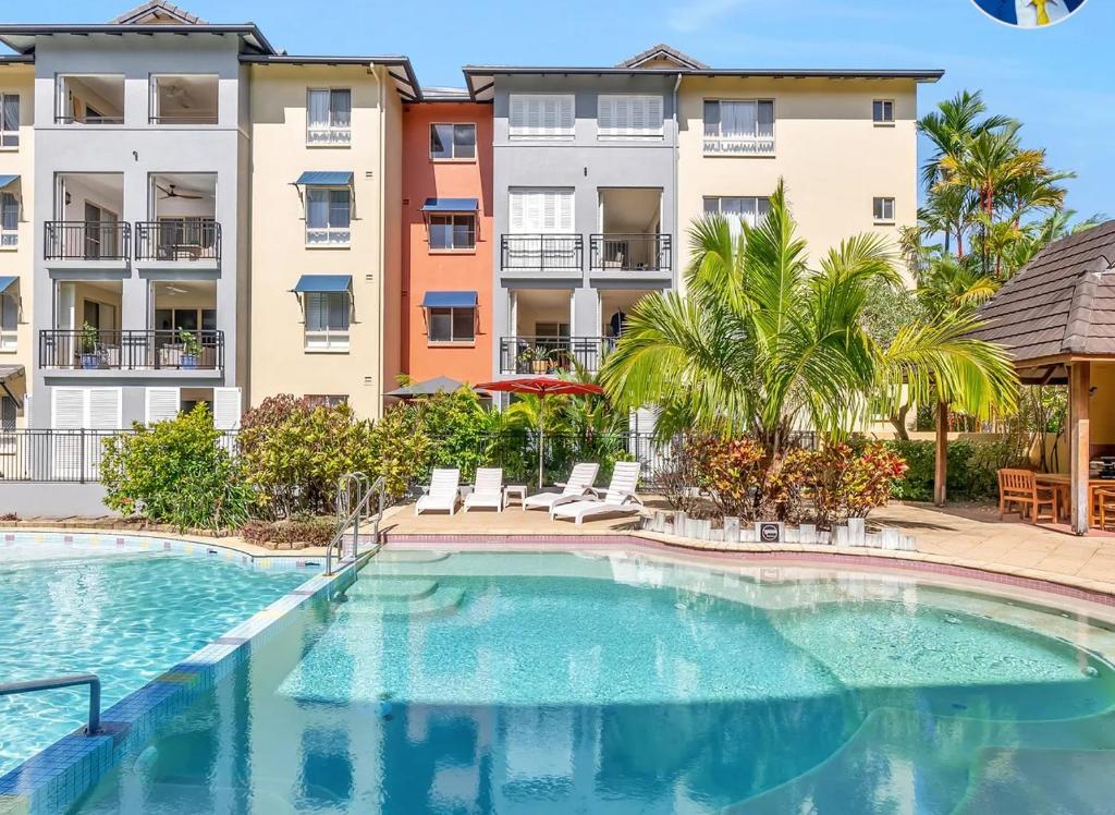 Cairns NorthLuxury tropical 2bedroom apartment in resort 4 swimming pools的部分公寓大楼前的游泳池