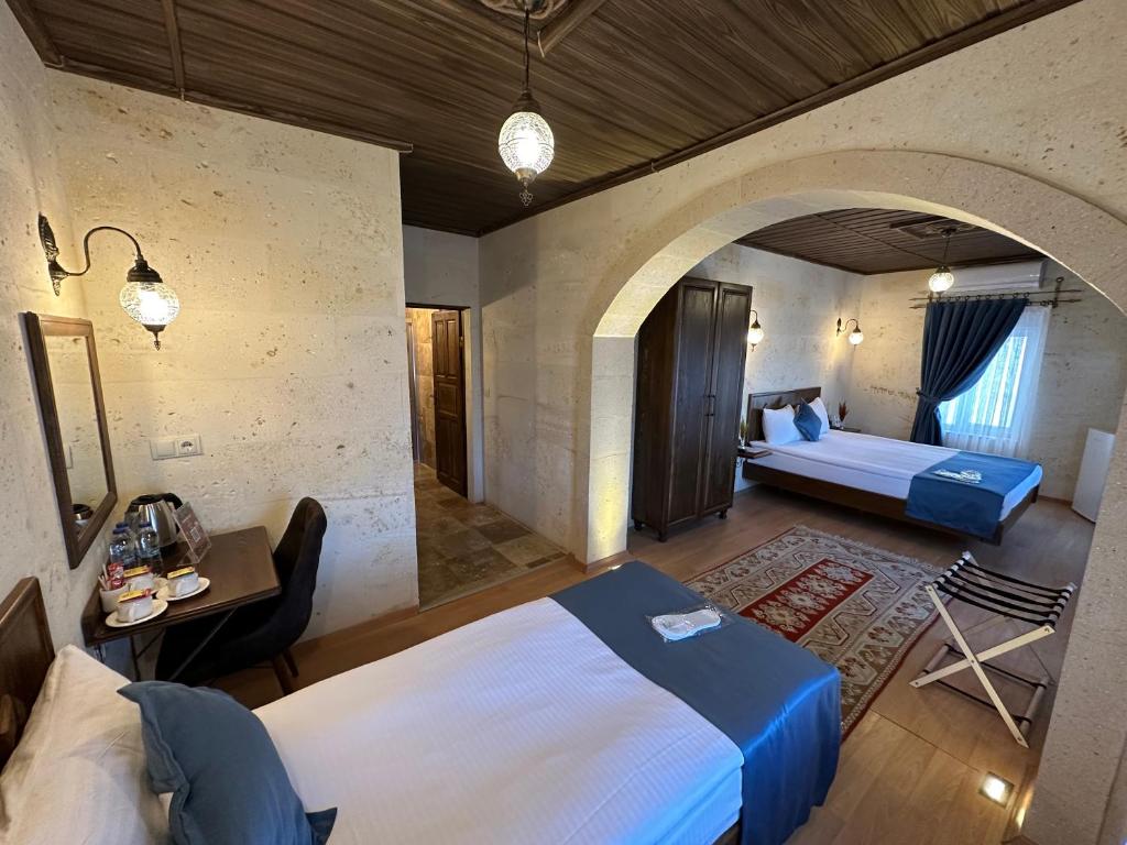 格雷梅Virtus Cappadocia Hotel Göreme的一间卧室配有一张床,另一间卧室配有沙发。