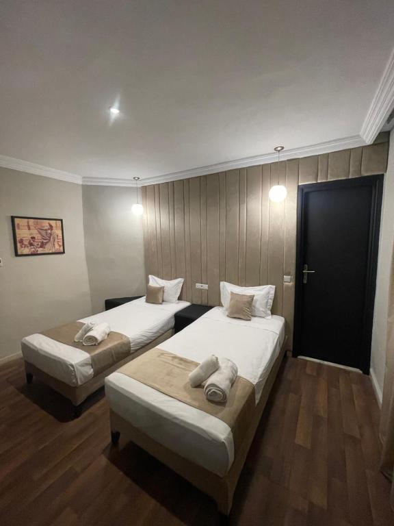 卡萨布兰卡Cadé Hotel的配有门的酒店客房内的两张床