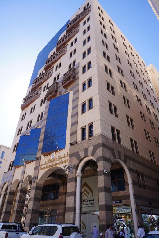 麦地那Roaa Al Andalus Hotel فندق رؤى الاندلس的一座高大的建筑,有蓝色的窗户,位于城市