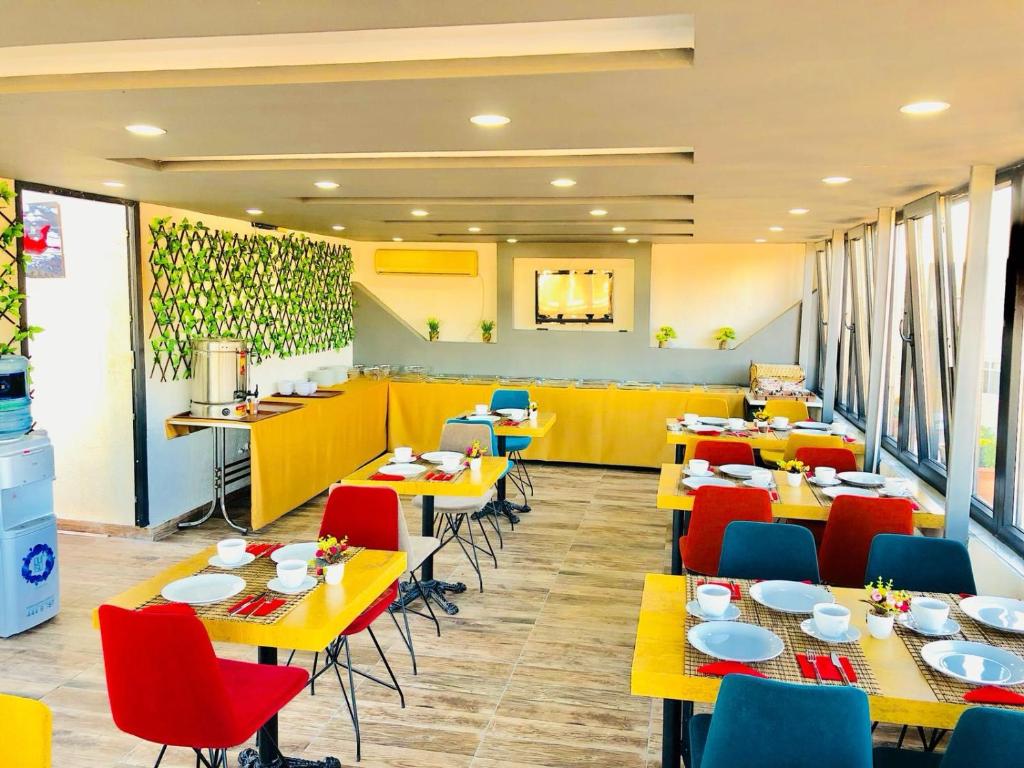 伊斯坦布尔MARDİA CİTY OTEL的餐厅设有黄色桌子和红色椅子