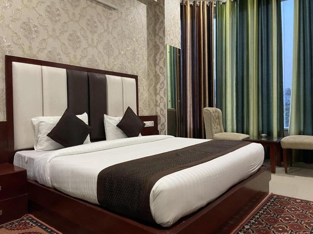 新德里Hotel Mannat International at Paschim Vihar的一间卧室,卧室内配有一张大床