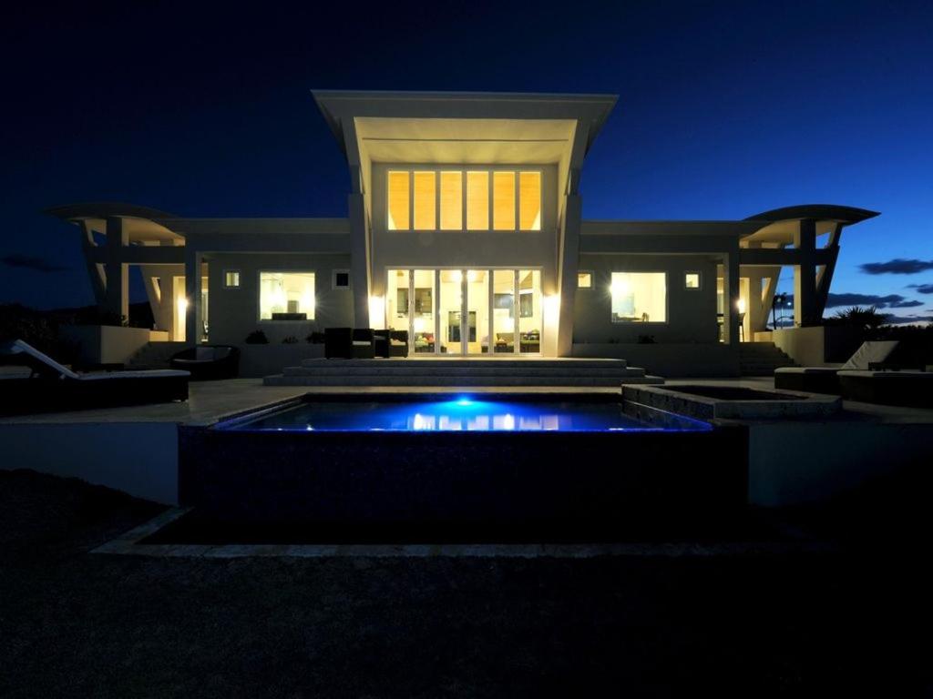 总督港Sky Beach Club Villa Waterfall 2 home的一座在晚上设有游泳池的大房子