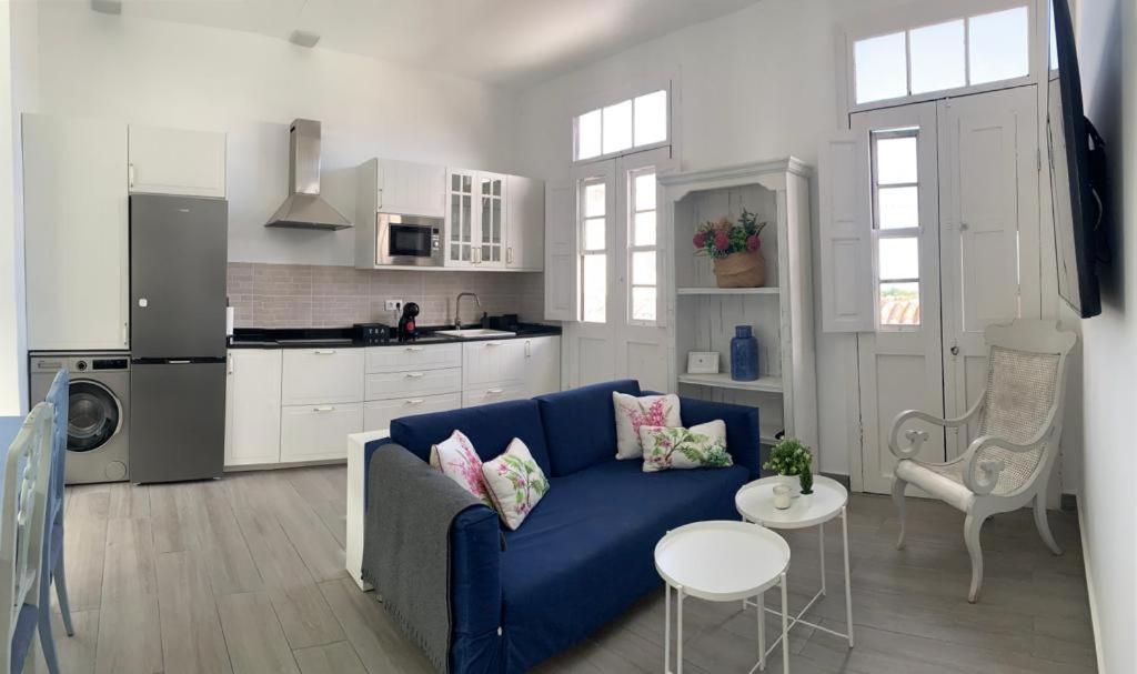 阿古洛Meriga的一间带蓝色沙发的客厅和一间厨房