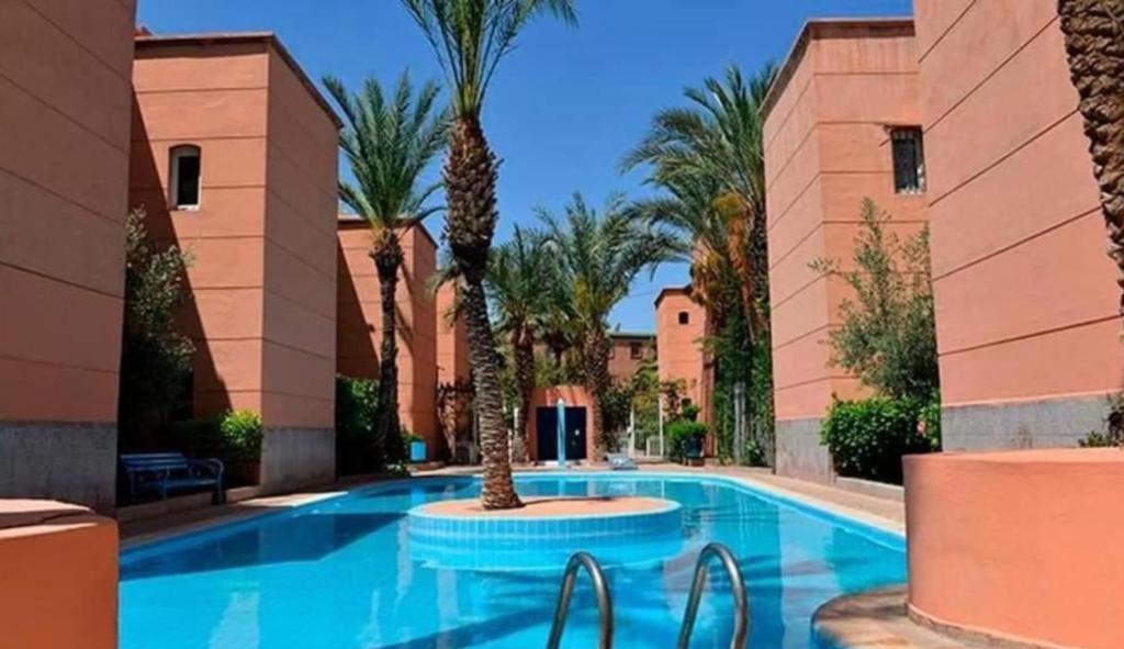 马拉喀什Riad Nezha的度假村内棕榈树游泳池