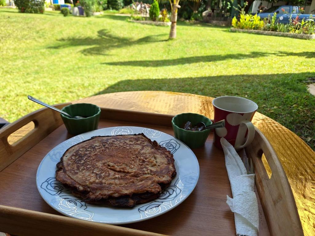 WaBeautyByNature scenery, room with TOP AC, private bath, restaurant的一张木桌,上面有盘子的食物