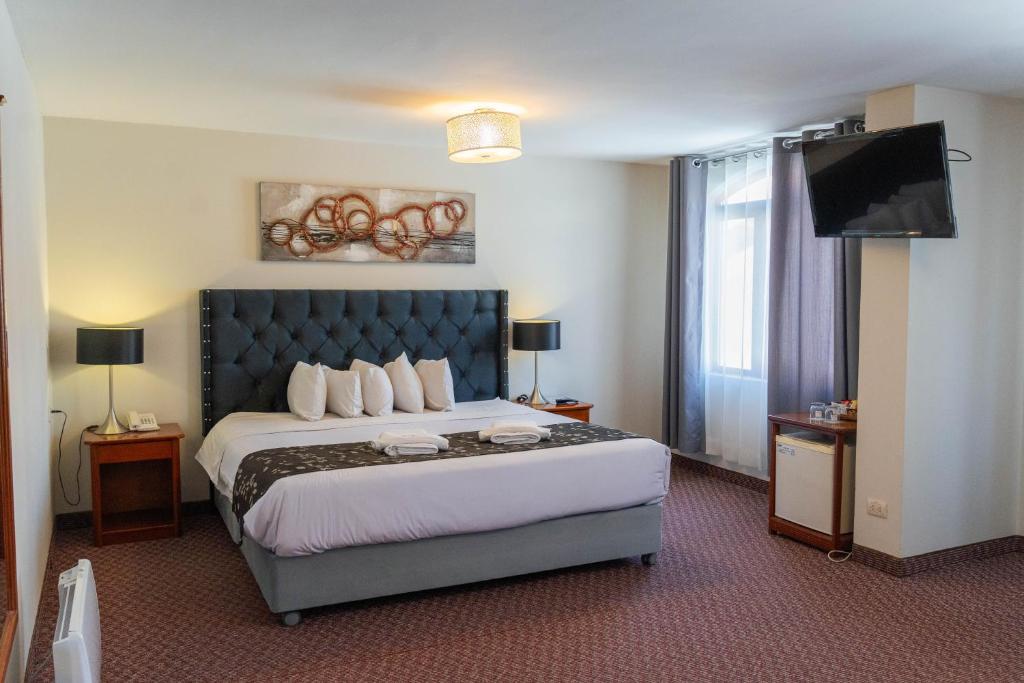 普诺Casona Plaza Hotel Puno的配有一张床和一台平面电视的酒店客房