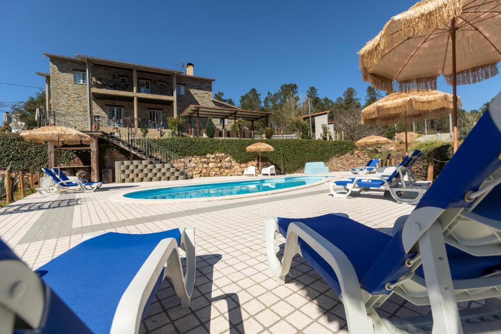 MouronhoQuinta do Rio Alva and Glamping Lodges的一座带蓝白色椅子的游泳池和一座建筑