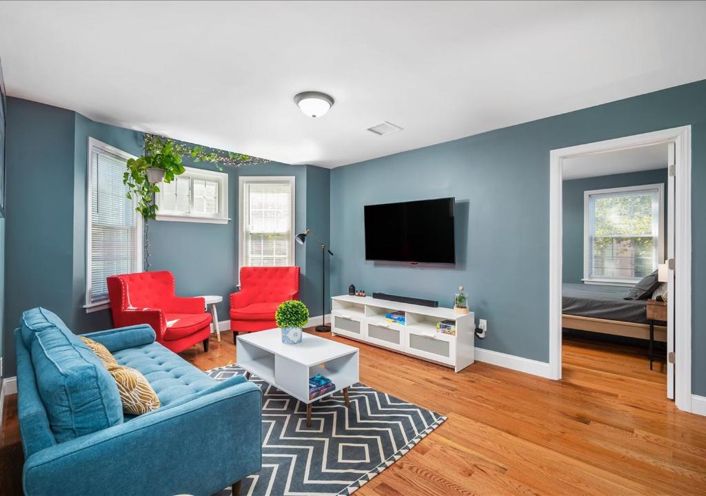 Mount VernonColorful, Comfy & Modern - Close to NYC - Parking!的客厅设有蓝色的墙壁和红色的椅子