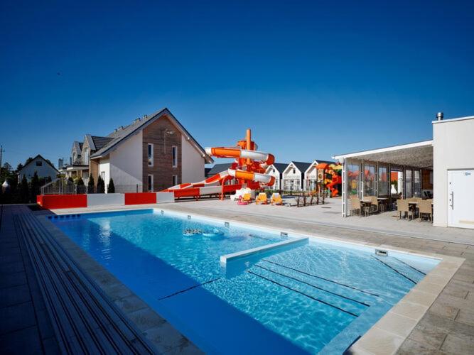萨比诺瓦Comfortable apartments, swimming pool, Sarbinowo的一个带滑梯水上公园的游泳池