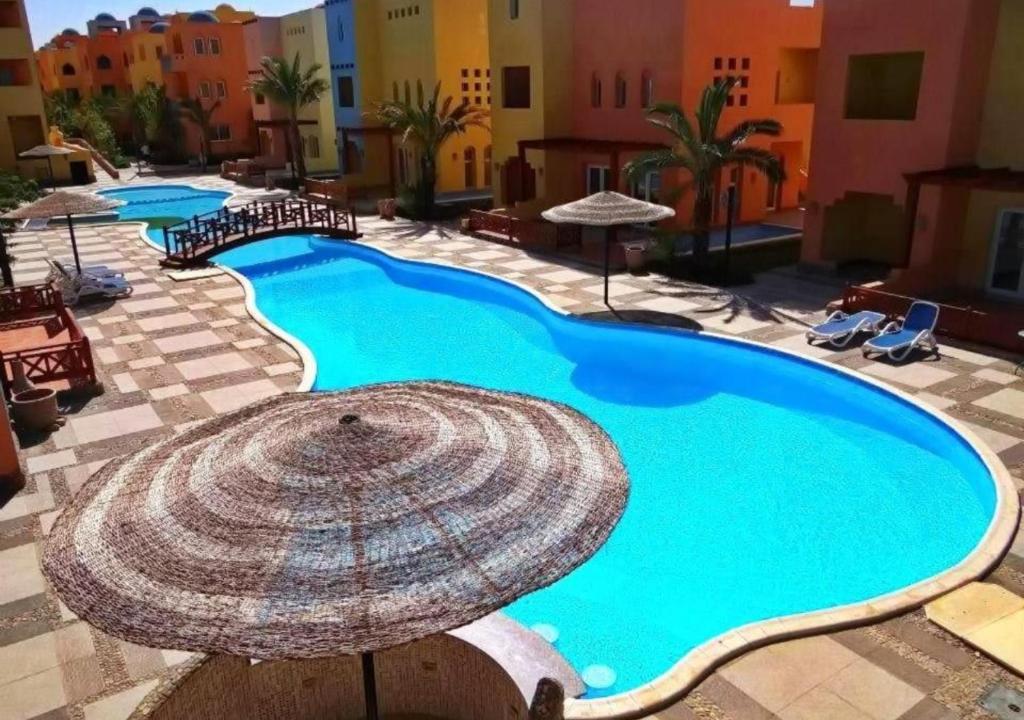 赫尔格达Al Dora Residence Suites Hurghada的度假村内的大型游泳池及其遮阳伞