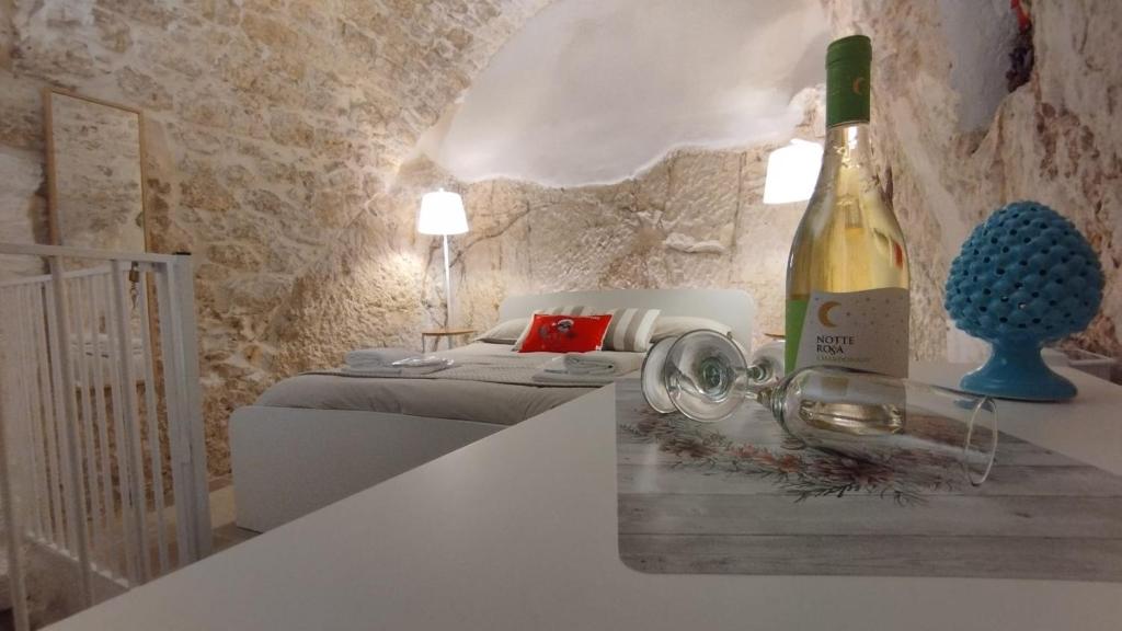奥斯图尼Cà Giò的卧室旁的柜台上摆放着一瓶葡萄酒