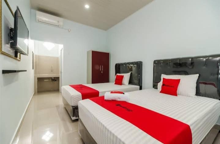 巨港RedDoorz Plus near Palembang Icon Mall 2的红色和白色的客房内的两张床
