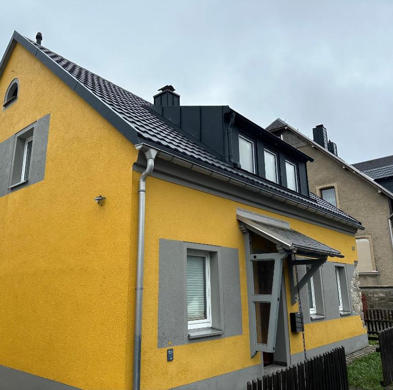 NeudorfBerghaisl Neudorf的黑色屋顶的黄色房子