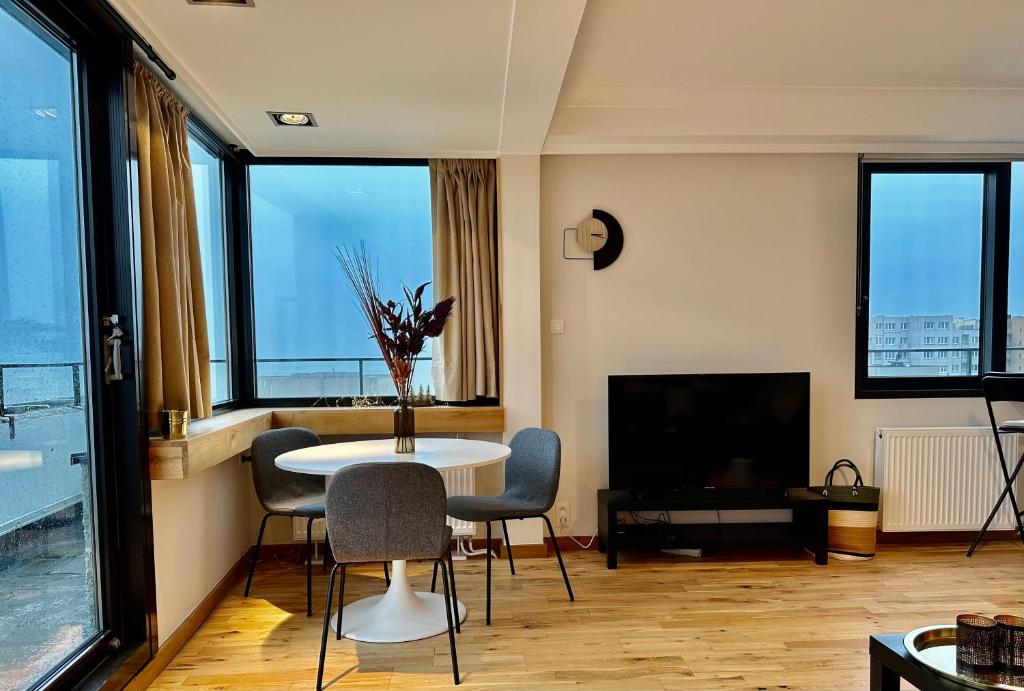 奥斯坦德Le Studio Grimaldi的客厅配有桌椅和窗户。