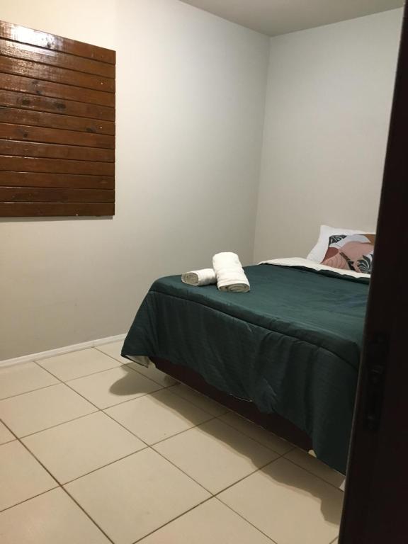 因比图巴Pousada Caminhos Do Mar的一间卧室配有一张带绿色床单的床和一扇窗户。