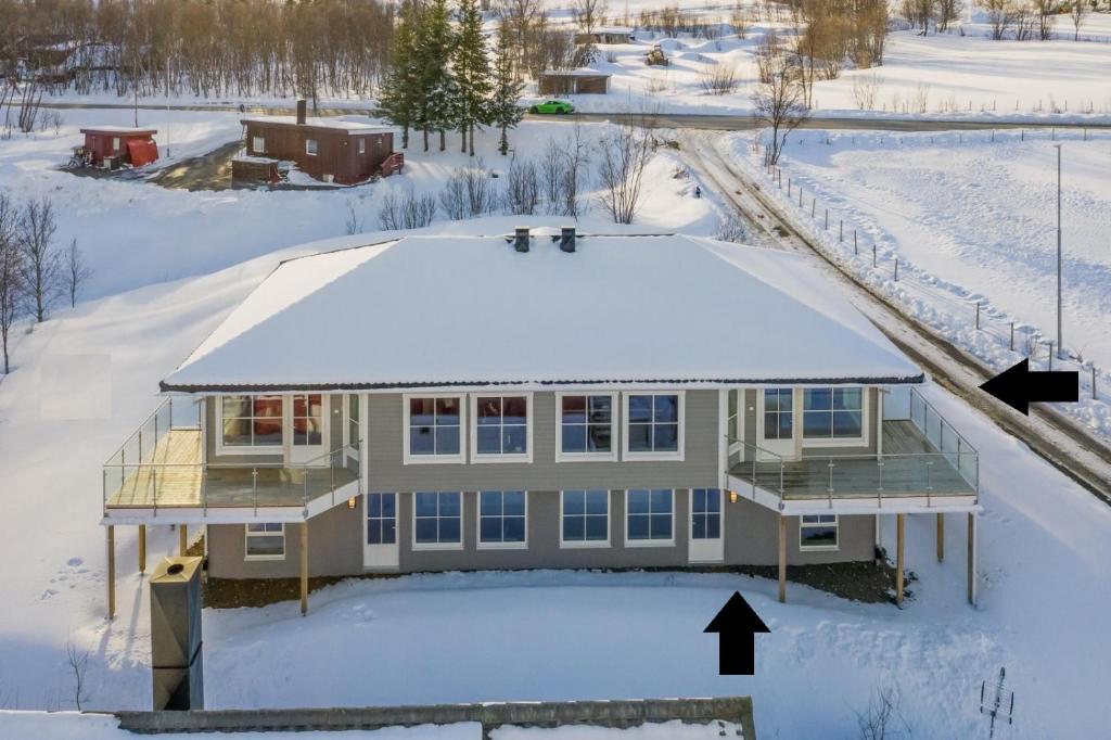 特罗姆瑟A Modern Home in Nature's Embrace的雪中房屋的空中景观