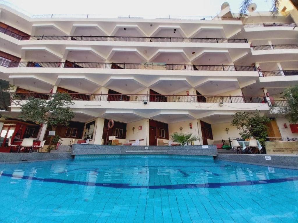 卢克索Rezeiky Hotel & Camp的一座大型建筑,设有大型游泳池