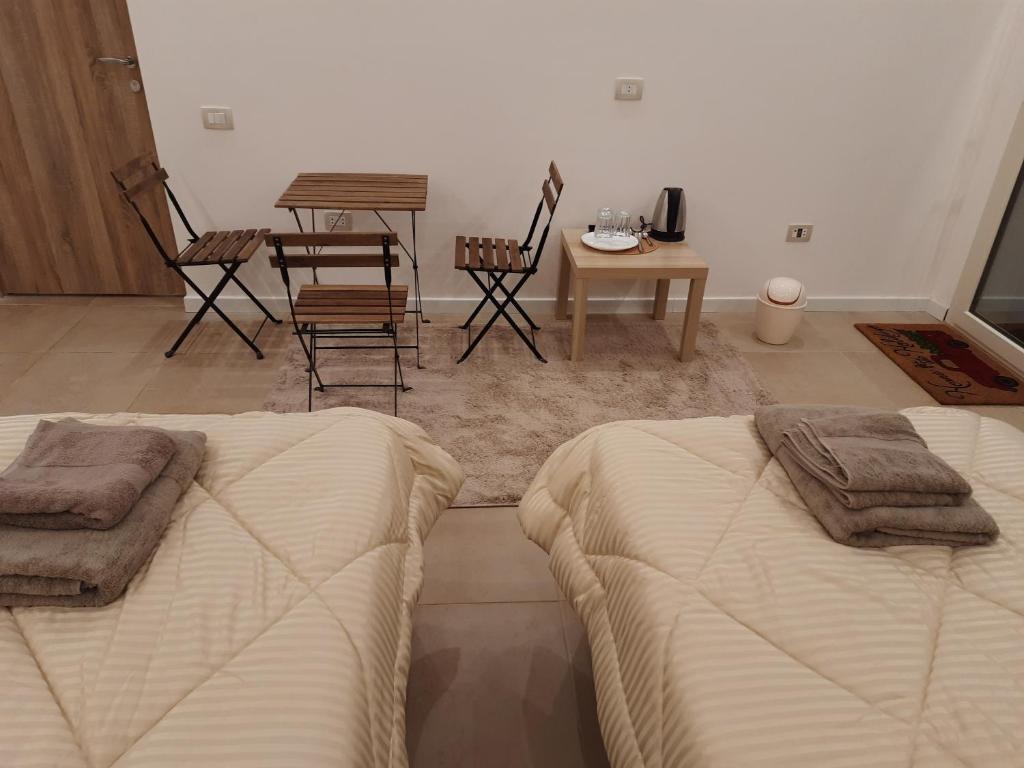 开罗Fantastic new rooms close to New Cairo Festival City and airport的一间卧室配有两张床和一张桌子及椅子