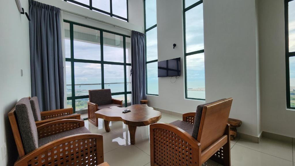 马六甲The Suites SGR Melaka的配有椅子和桌子的房间,窗户
