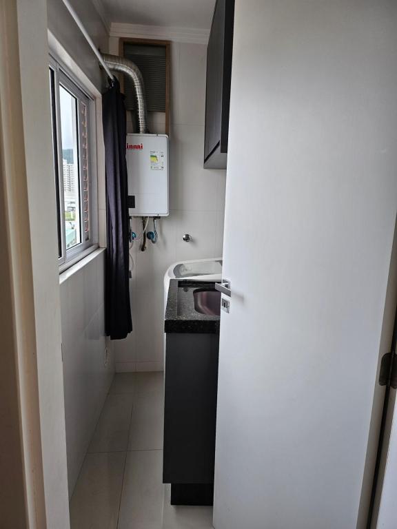 伊塔佩马Apartamento 01的一个带水槽和窗户的小厨房