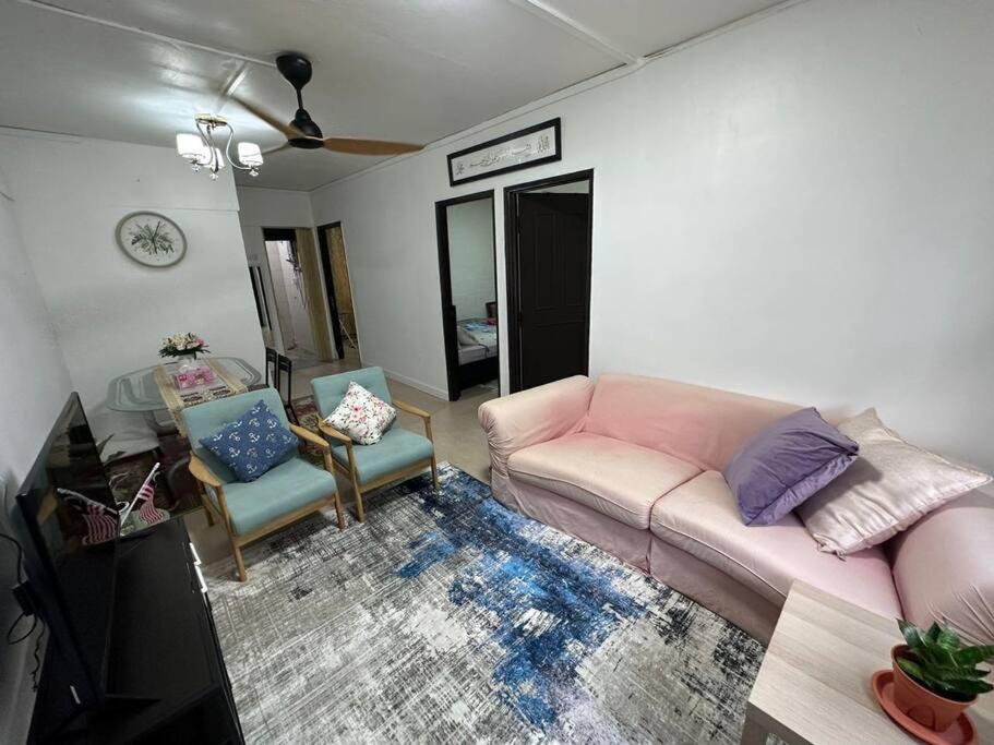 吉隆坡Iris Homestay @ Taman Melati的客厅配有粉红色的沙发和两把椅子