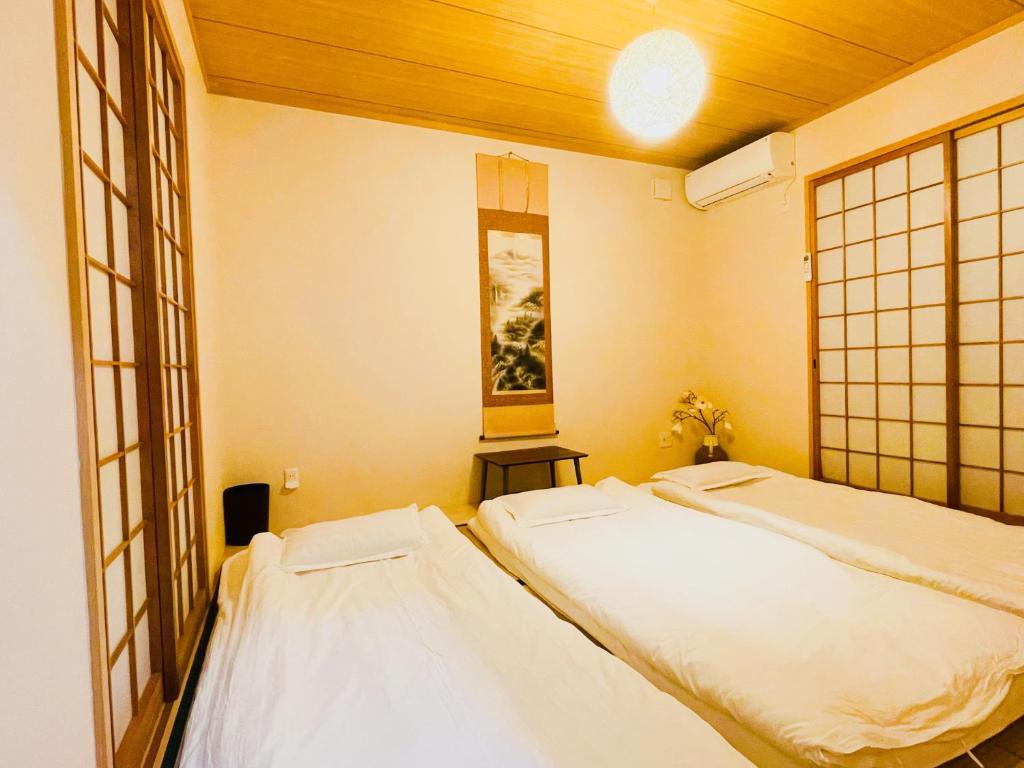 大阪無料駐車場 3階建て一軒家 家族グループ最適 3寝室ヴィラ USJ道頓堀通天閣近い子連れok的带窗户的客房内设有两张单人床。