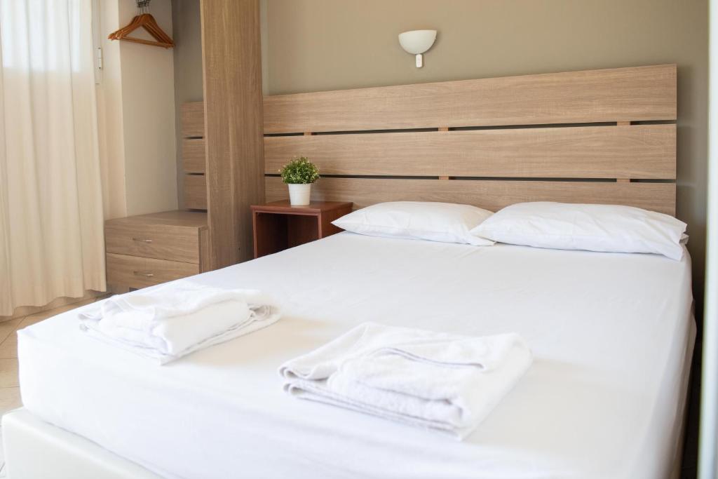 TrikovilónTota Marinou的卧室配有白色的床和2条毛巾