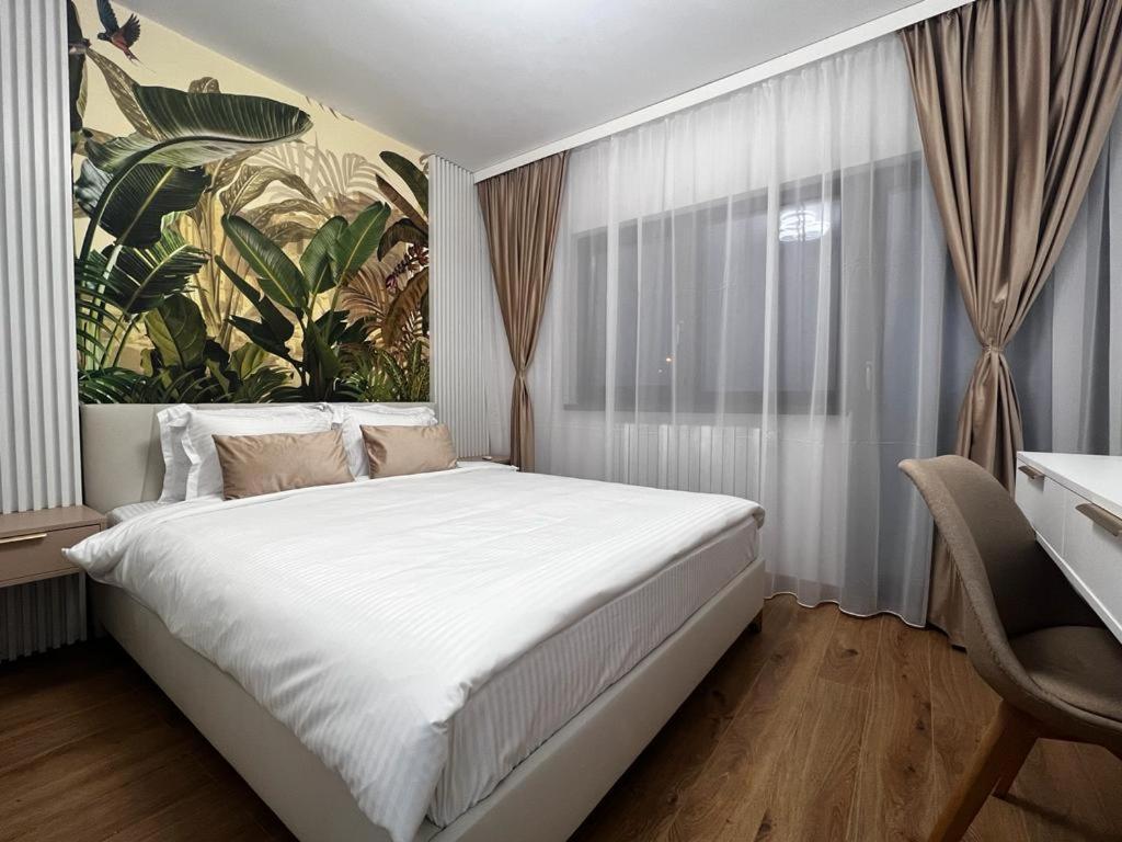 皮特什蒂Florilor Residence I的卧室配有一张白色大床,墙上挂有绘画作品