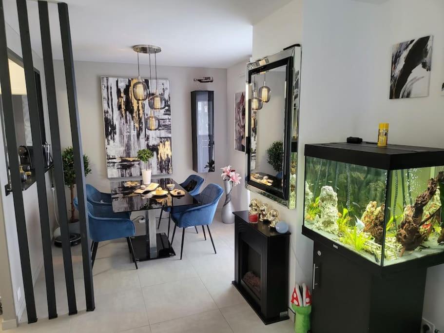 圣热尼普伊Appartement neuf moderne + parking, Genève的客厅设有鱼缸和餐桌