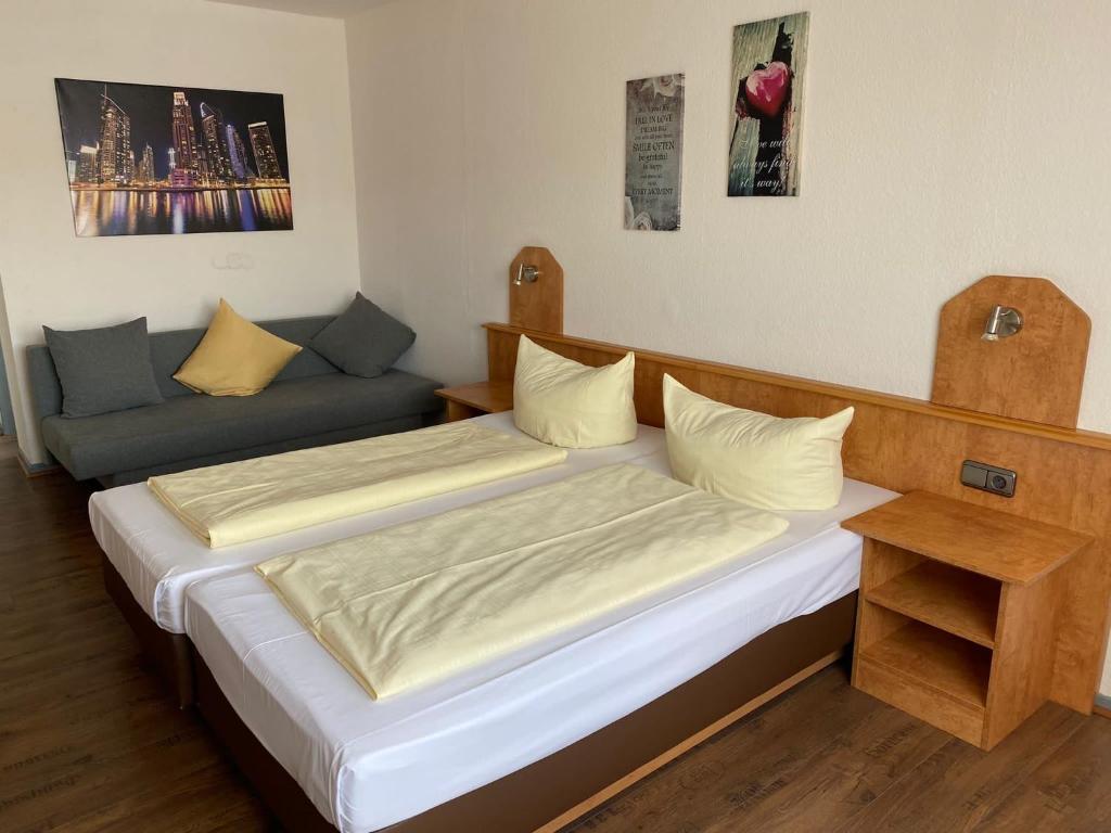 伊德施泰因Hotel Sonne - Haus 1的一间带两张床和一张沙发的卧室
