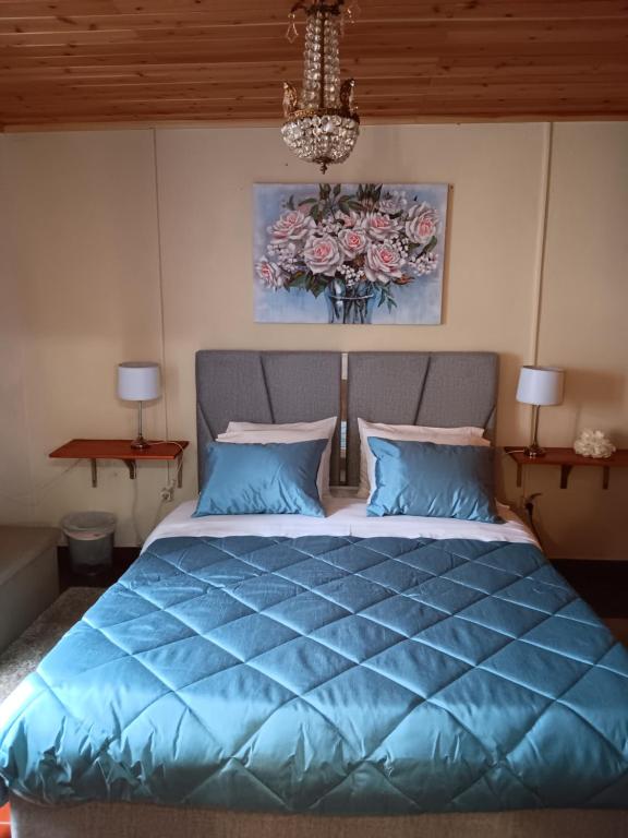 富尔纳斯Casa do Vale Encantado的一间卧室配有一张带蓝色棉被的床