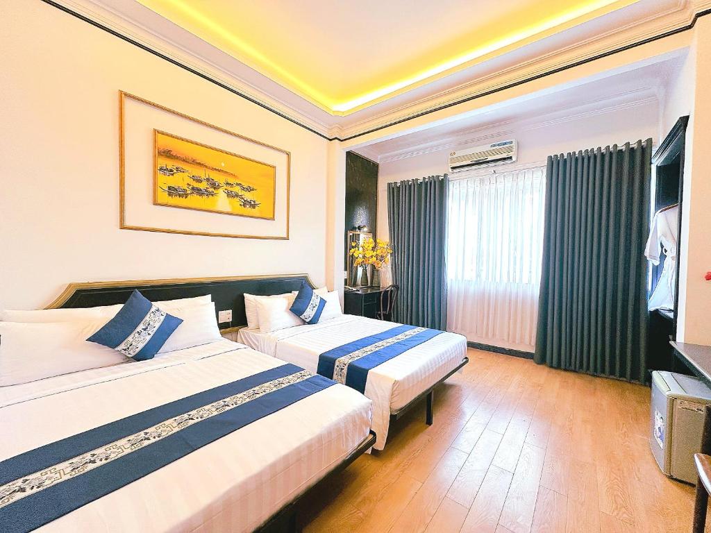 胡志明市New Star Inn Boutique Hotel-Near Bến Thành Market的酒店客房设有两张床和电视。