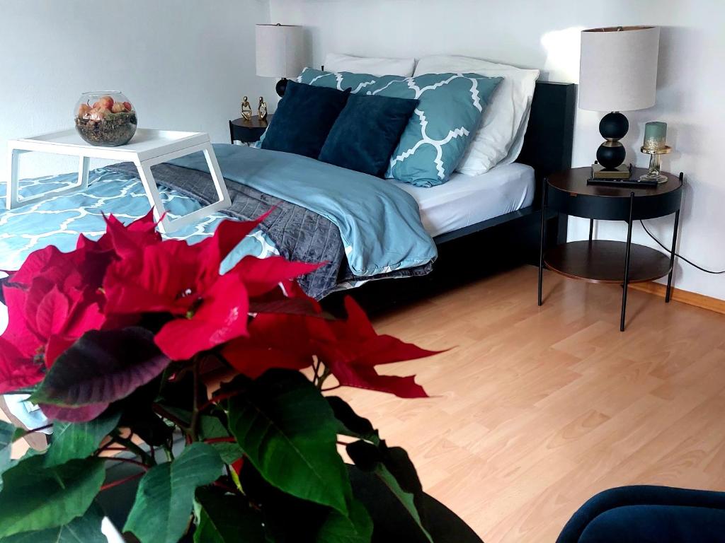 亚琛Central and calm appartement in Aachen的一间卧室配有一张带蓝色枕头和植物的床