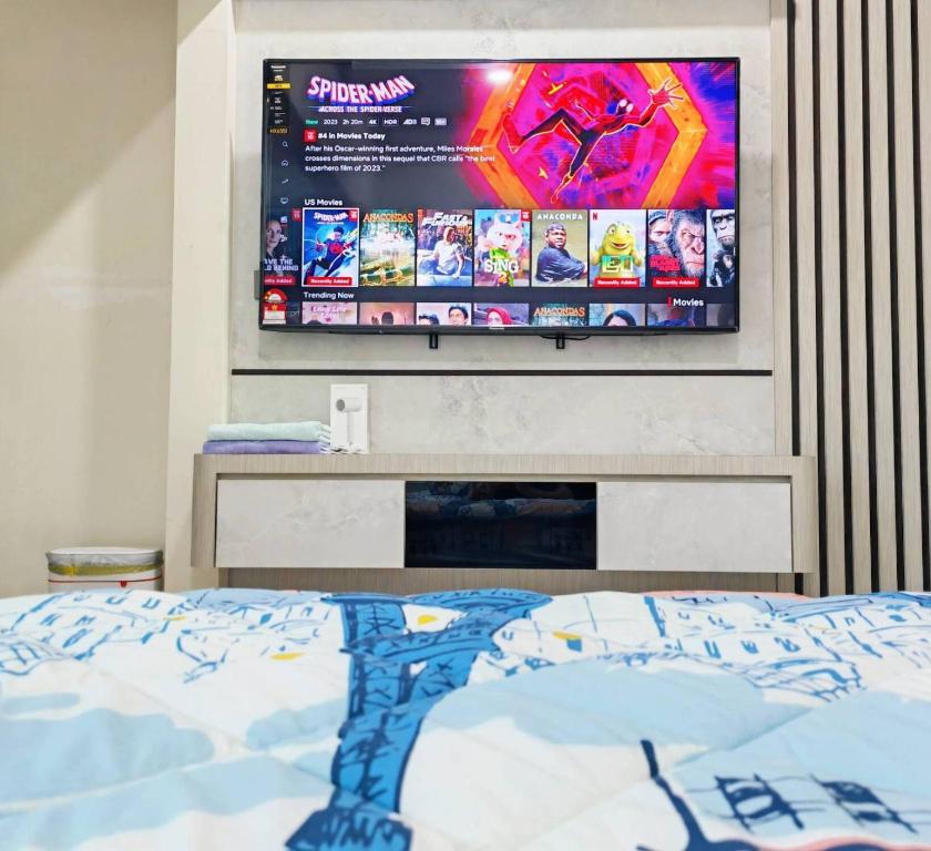 峇株巴辖UG Homestay BP - Netflix & 4 Air-Con Rooms的卧室配有挂在墙上的电视