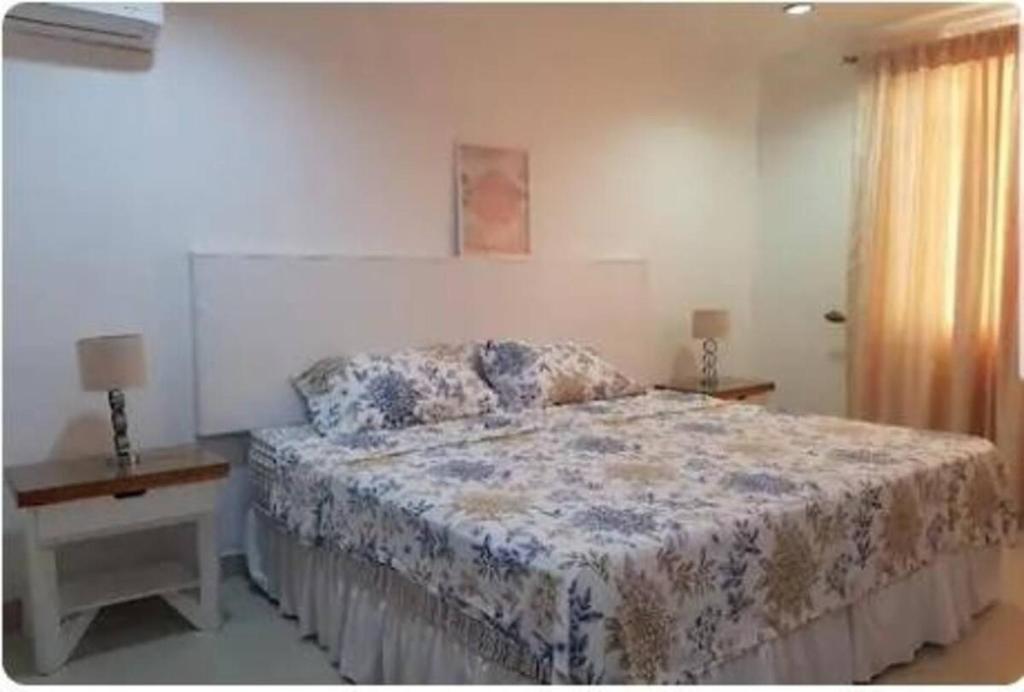 SamborondÃ³nHabitacion independiente en Samborondon的一间卧室配有一张床、两盏灯和一个窗户。