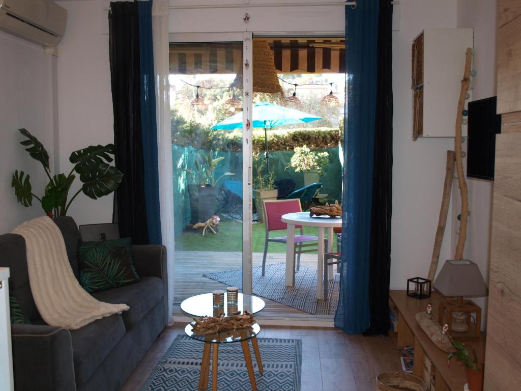 圣拉斐尔Studio le Mistral的客厅配有沙发和带雨伞的桌子