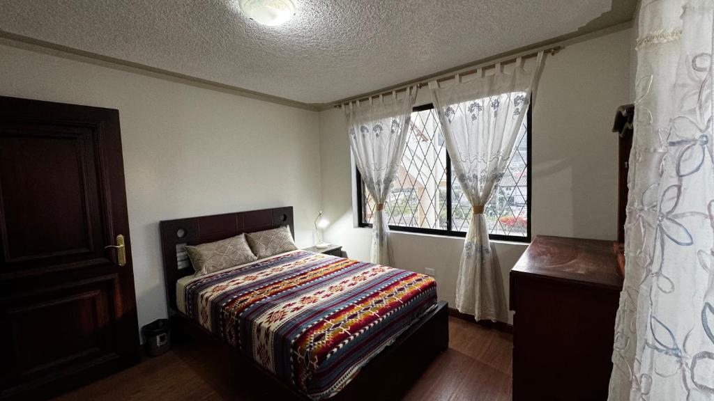 奥塔瓦洛Wasi Golde oro的一间卧室设有一张床和一个窗口