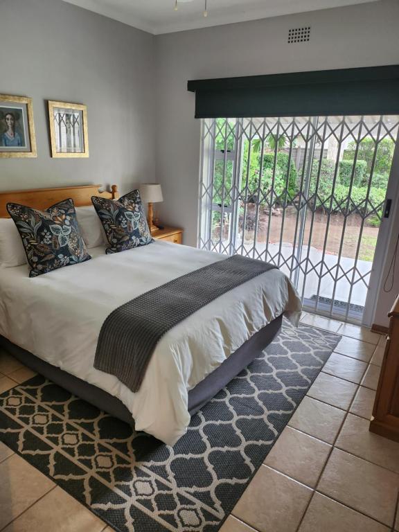 弗莱海德Rosewood Guest Cottage的一间卧室设有一张大床和一个窗户。