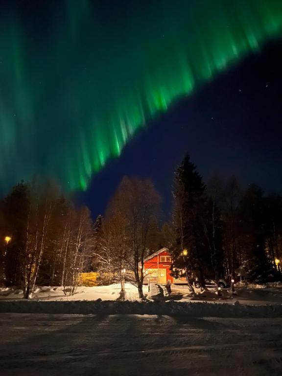 Vikajärvi阿霍森罗曼莫吉特度假屋的天空中一幅房子上的极光图