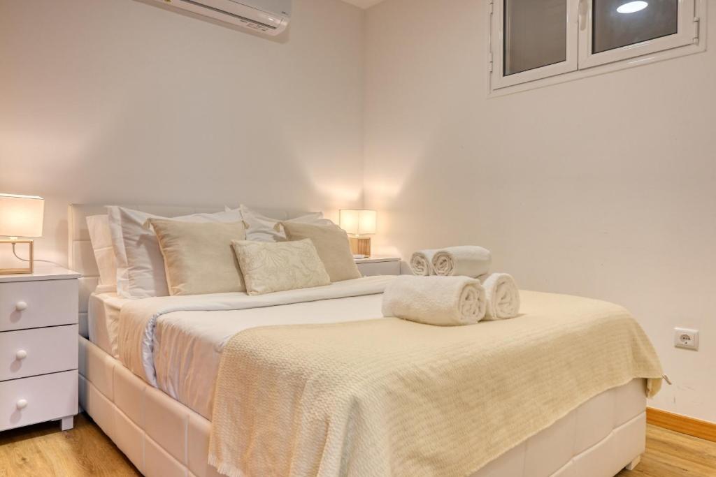 塞沙尔Casa Familia Pestana 1, a Home in Madeira的白色卧室配有两张带毛巾的床