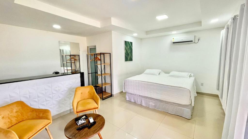 费尔南多 - 迪诺罗尼亚Terras Verdes Residence的一间卧室配有一张床、一把椅子和一张桌子