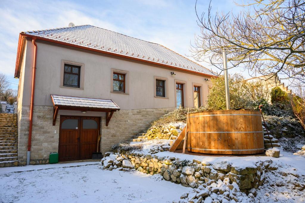 BakonyjákóJákó Ház的雪中前方有浴缸的房子