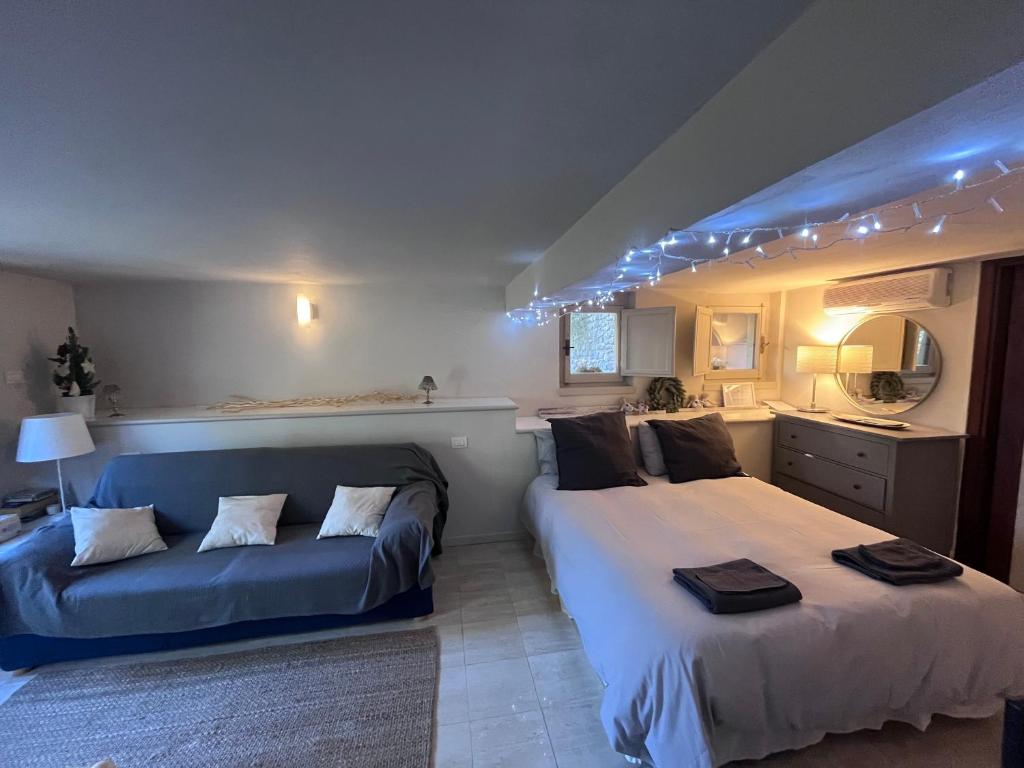 阿雷佐la casetta di anita in toscana arezzo的一间卧室配有两张床和蓝色的沙发