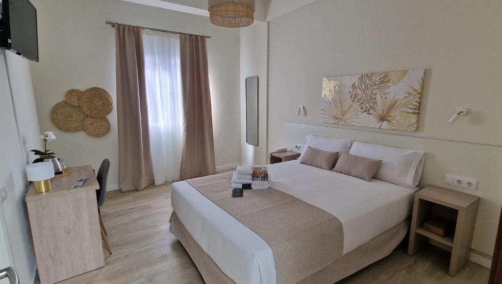 大加那利岛拉斯帕尔马斯Le Petit Palü Las Palmas的白色的卧室设有一张大床和一个窗户